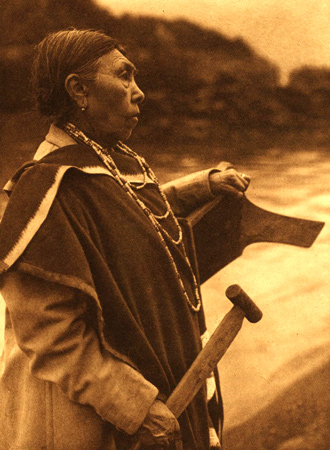 Woman holding paddle standing at the bow of a canoe