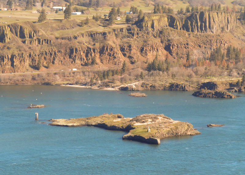 A large basalt barren rock in the middle of the river with a flat top