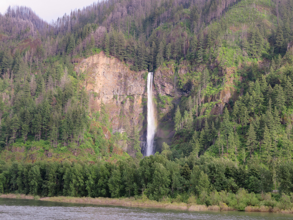 A tall waterfall plummets down to the Columbia River
