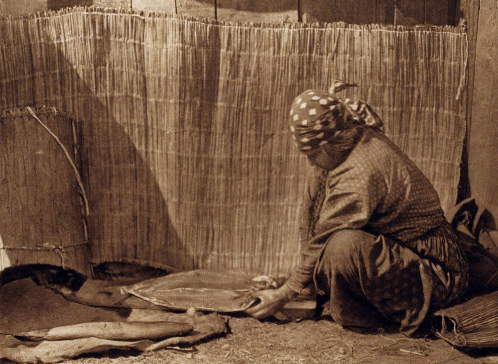 Wishram woman cleaning salmon