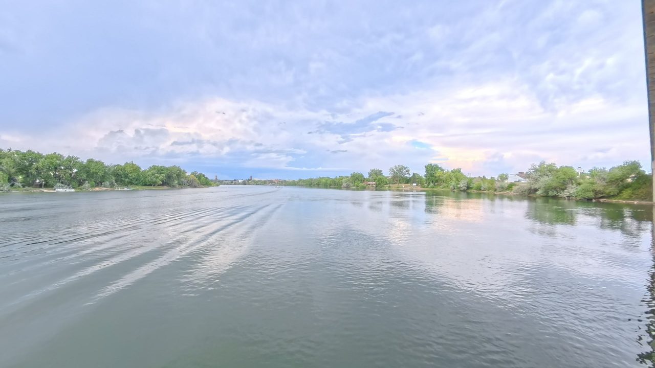 The Missouri River between wooded banks under towering clouds, 2025