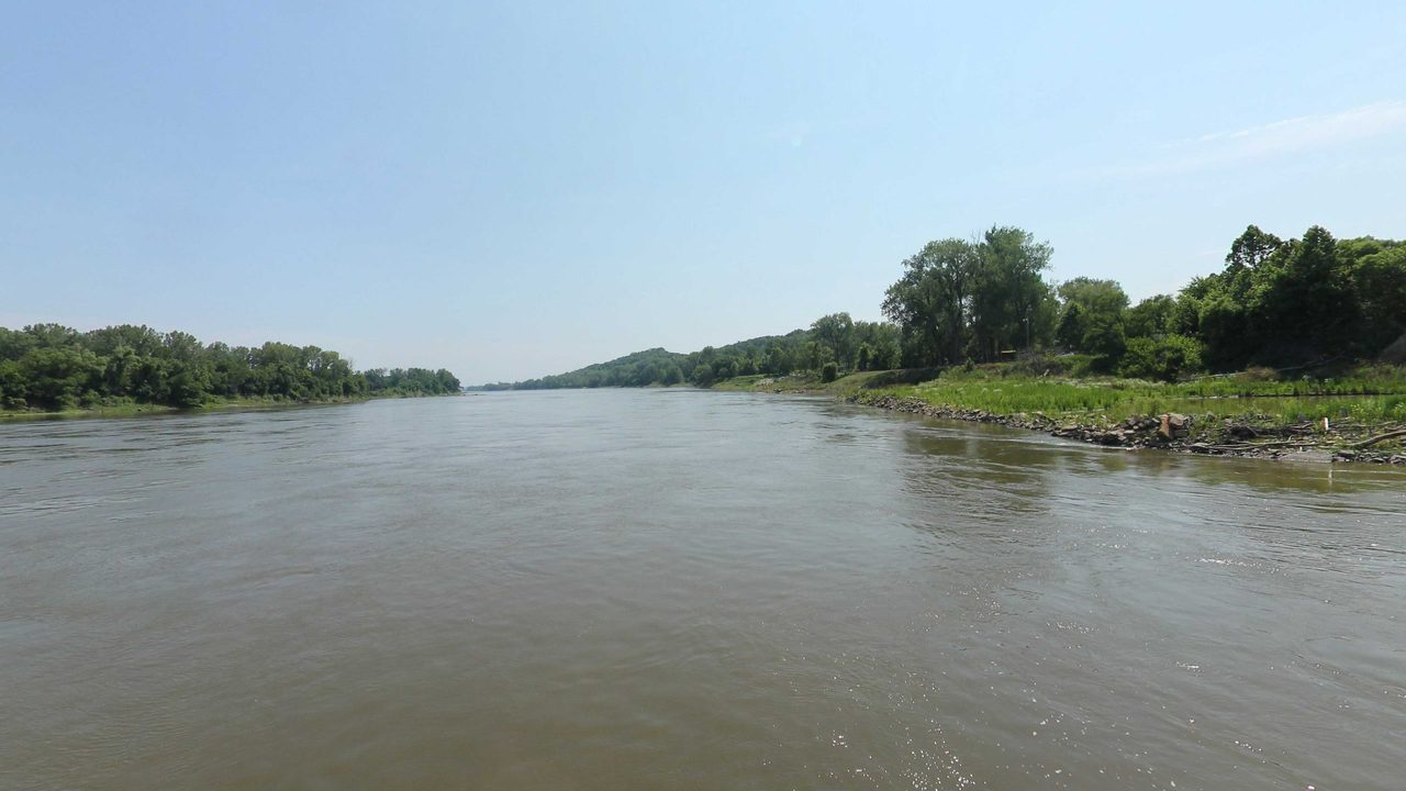 The Missouri River with a grassy, wooded bank on the right, 2023